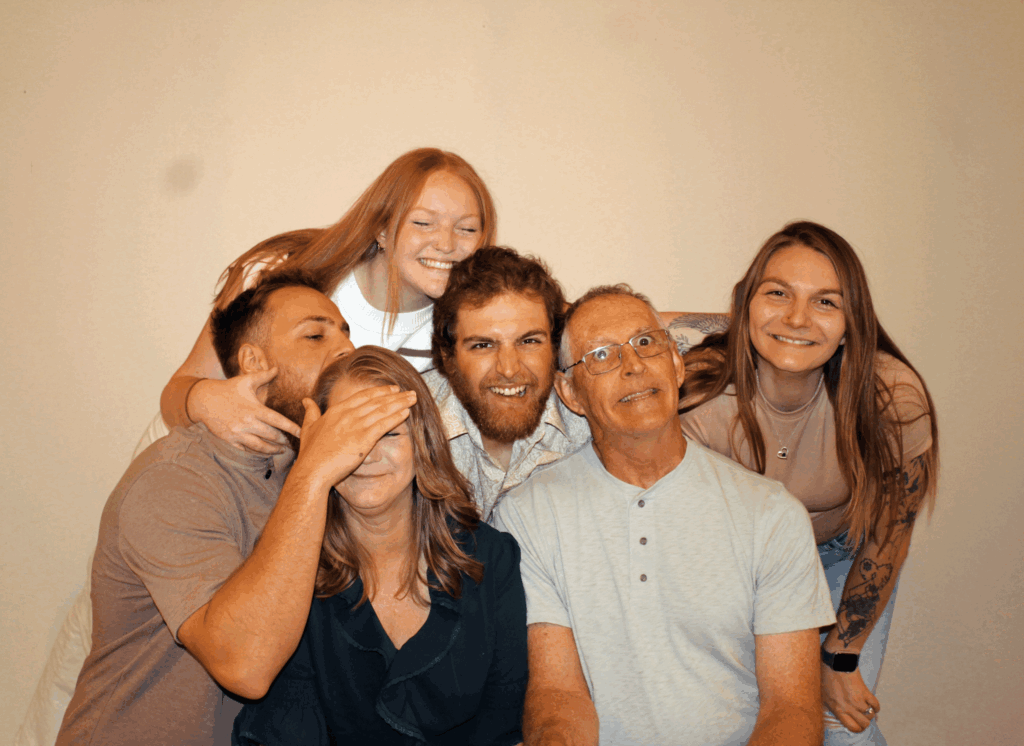 Kayla and her family posing for a group photo, expressing fun emotions.